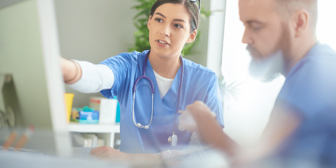 Male and female healthcare workers have a meeting near a computer