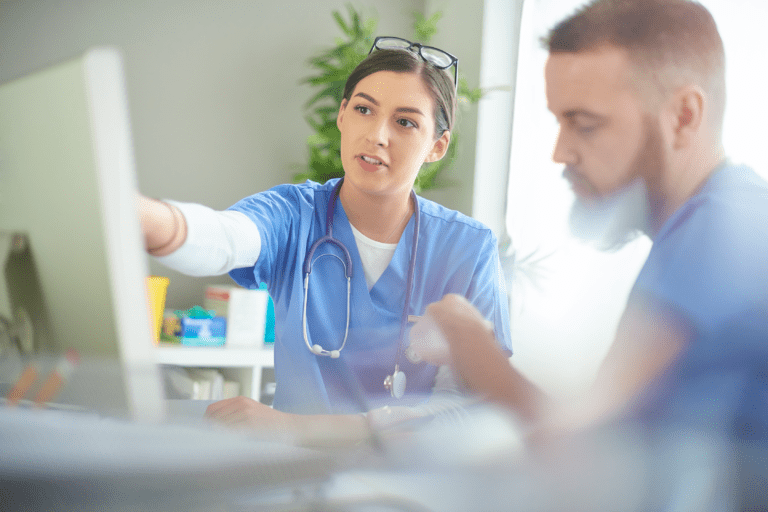 Male and female healthcare workers have a meeting near a computer