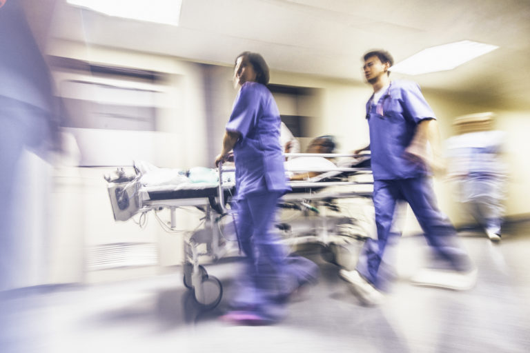Doctors and nurses pulling hospital trolley blurred image