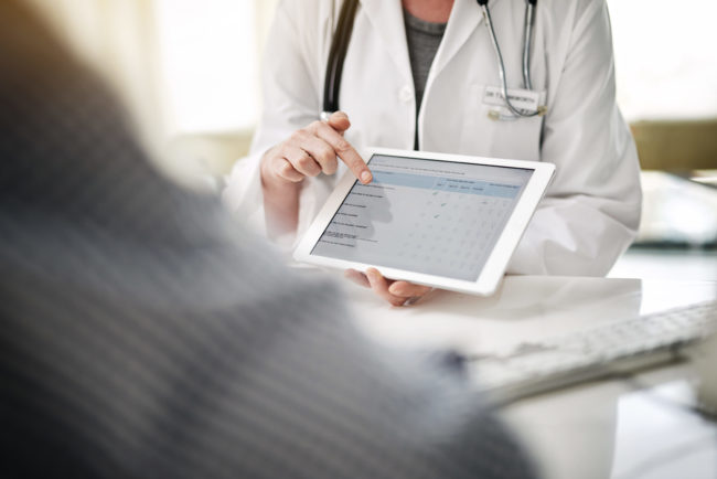 Shot of a doctor showing a senior patient some information on a digital tablet in her office