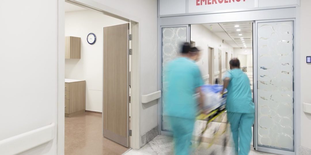 blurred photo of doctors wheeling patient into the emergency department