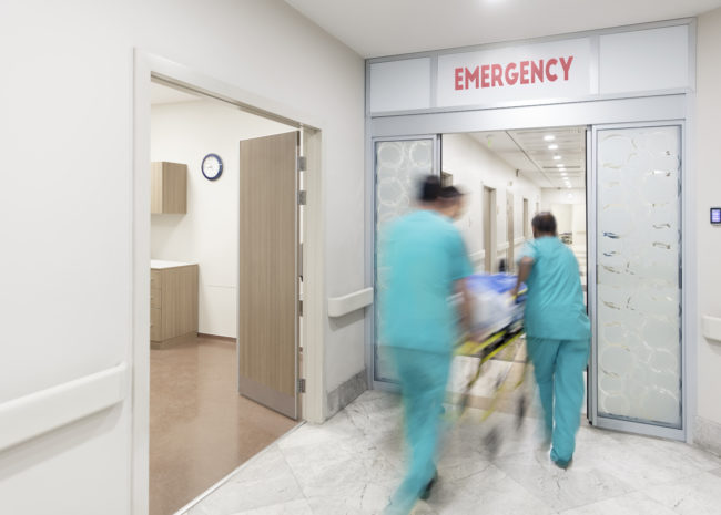 blurred photo of doctors wheeling patient into the emergency department