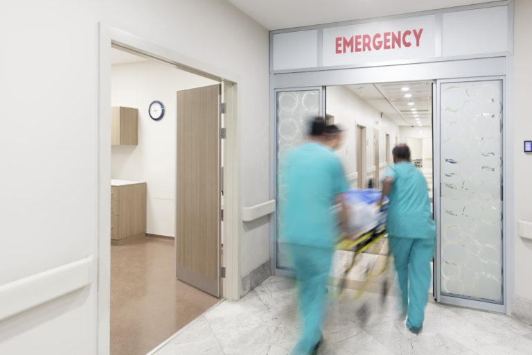 blurred photo of doctors wheeling patient into the emergency department