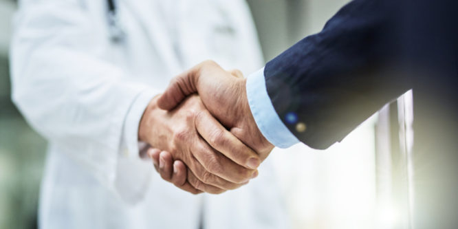 Cropped shot of a doctor shaking hands with a businessman