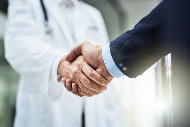 Cropped shot of a doctor shaking hands with a businessman