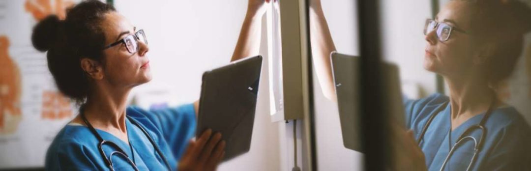 nurse with tablet points to image on the wall