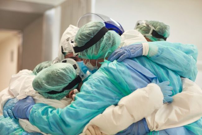 Doctors and Nurses With Arms Around Each Other in Support