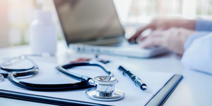 Stethoscope with clipboard and Laptop on desk Doctor working in hospital writing a prescription Healthcare and medical concept test results in background vintage color selective focus.