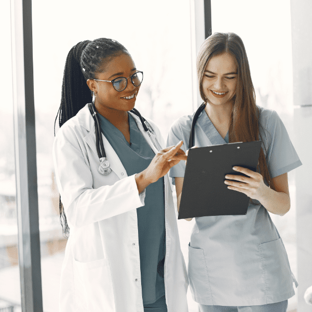 Young women nurses smiling while looking at a clipboard
