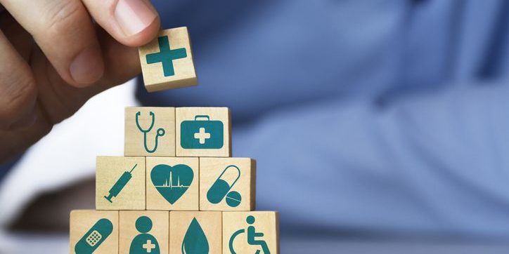 Medical health insurance concept. Men's hand arranging wood blocks with healthcare medicine icons