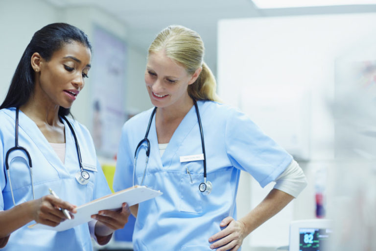 Nurses discussing over documents in hospital