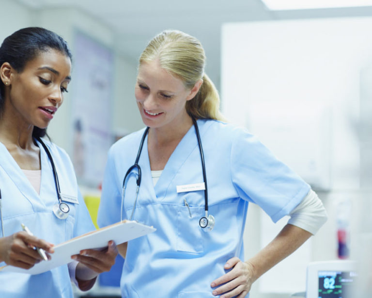 Nurses discussing over documents in hospital